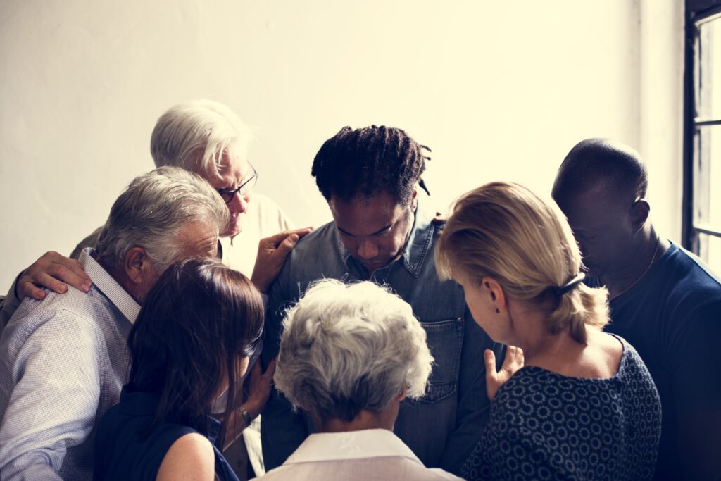 Group of people stands close to each other in a support circle